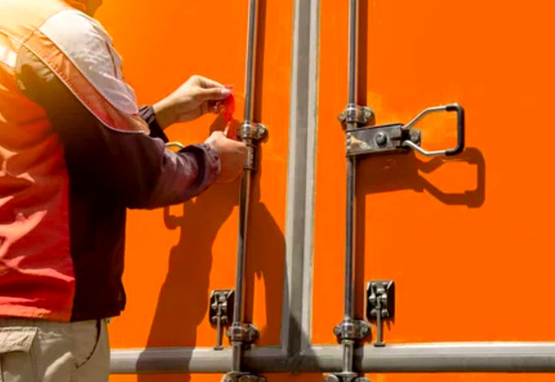 Colaborador colocando un sello de seguridad en la puerta de un contenedor